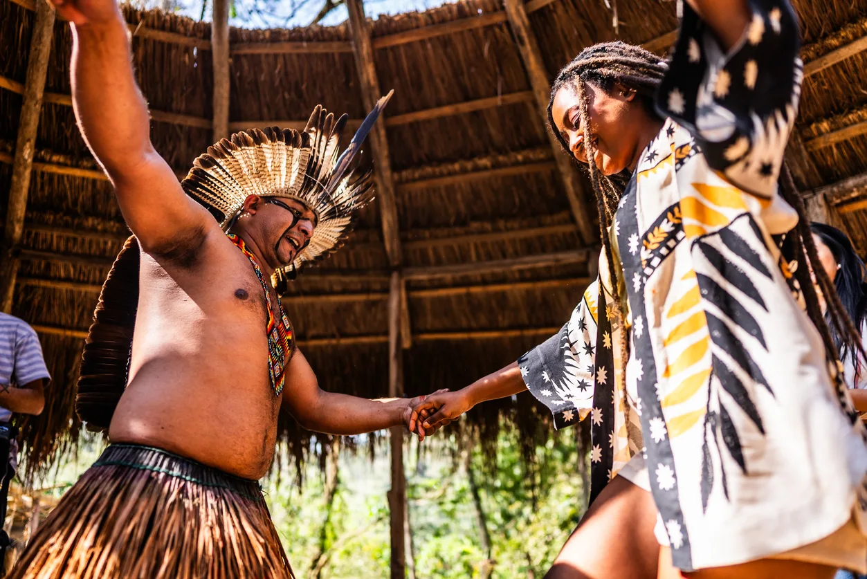 Indigenous people from the Wassú tribe and tourists performing traditional dance in the village